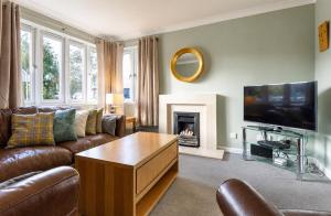 a living room with a couch and a fireplace at Tigh na Lochan in Aviemore