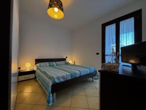 a bedroom with a bed and a flat screen tv at Residence Mairen a pochi passi dal mare in Rosolina Mare