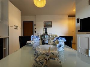 a table with a bottle of wine and glasses on it at Residence Mairen a pochi passi dal mare in Rosolina Mare