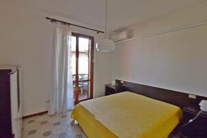a bedroom with a yellow bed and a window at Casavacanze Zeus in Marciana Marina