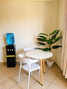 a table and two chairs and a plant in a room at Evara Luxe stay in Mombasa