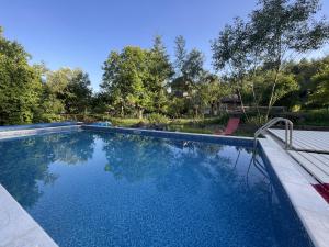 a swimming pool with blue water in a yard at Guest House Danver in Yaremche