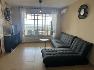 a living room with a couch and a table at Rayon de vacances T3 spacieux et bien équipé in La Possession