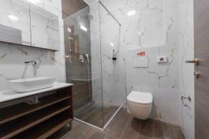 a bathroom with a toilet and a sink and a shower at Old Nikiti's Hotel in Nikiti