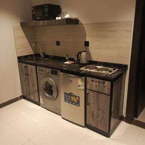 a kitchen with a stove and a washing machine at شقق ثري ستار للشقق المخدومة 4 in Riyadh