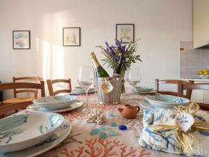 a table with plates and glasses and a bottle of wine at Residence Corallo con piscina in Rosolina Mare