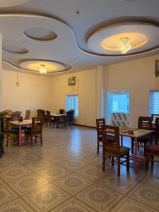 a dining room with tables and chairs and lights at The Royal Vintage Resort in Majhola