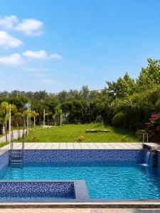 a swimming pool with a view of a park at The Royal Vintage Resort in Majhola