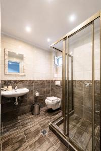 a bathroom with a toilet and a sink and a shower at Salty Sea View Apartments in Polychrono