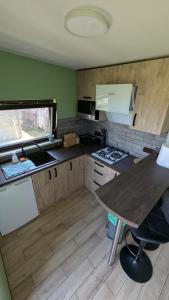 a kitchen with wooden cabinets and a table in it at Kupiškėnų Starkėnas in Palėvenėlė