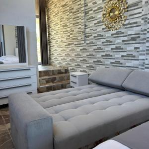 a living room with a couch and a brick wall at Villa Neimi in Ksamil