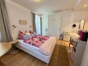 a bedroom with a bed with a pink comforter at Ferienwohnungen am See _ Hinterseer in Schliersee