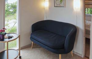 a blue chair in a room with a table at Nice Apartment In Farsø With Heated Swimming Pool in Farsø +6 photos