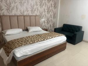 a bedroom with a bed and a blue chair at The Royal Vintage Resort in Majhola