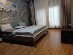 a bedroom with a bed with a blue headboard at Cameo Villa in Kigali