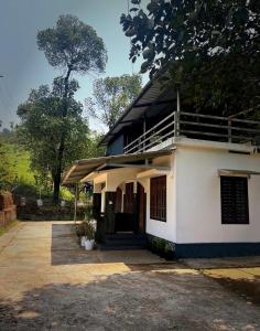a white house with a balcony on the side of it at Grass root by shelters in Vayittiri