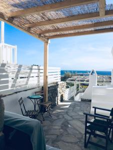 a patio with chairs and a table and a view of the ocean at Naiada Home with Sea View in Mykonos