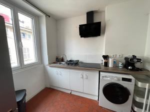 a kitchen with a washing machine and a tv on the wall at studio idealement situé in Marseille