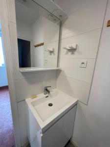 a white bathroom with a sink and a mirror at studio idealement situé in Marseille