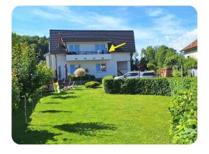 a house with a yard with a yellow arrow on it at Apartma pri lovcu in Trzin