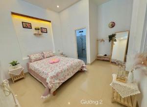 a bedroom with a bed with two pink donuts on it at mongmerhomestay in Thôn Lại Thê