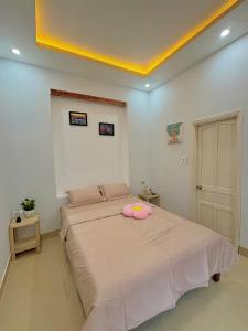 a bedroom with a large bed with a pink pillow on it at mongmerhomestay in Thôn Lại Thê