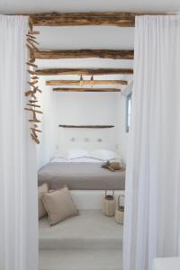 ミクリ・ヴィグラにあるAnnais Casaの白い壁のベッドルーム1室、白いカーテン付きのベッド1台が備わります。