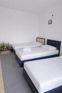 a row of four beds in a room at Airport Double Room in Kamëz