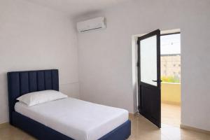 a bedroom with a bed and an open door at Airport Double Room in Kamëz