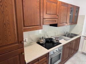 a kitchen with wooden cabinets and a stove top oven at Casa Narciso, semi-detached cottage in Marina di Massa