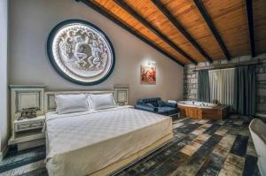 a bedroom with a king sized bed and a couch at Assos Dionysos Special Class Hotel Adults Only 12 years in Behramkale