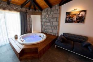 a large bath tub in a room with a couch at Assos Dionysos Special Class Hotel Adults Only 12 years in Behramkale +110 photos