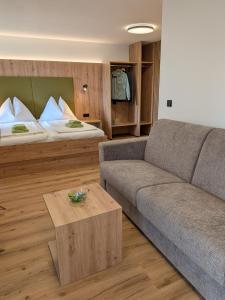 a living room with a couch and a bed at Pension Holzapfel in Sankt Georgen im Attergau
