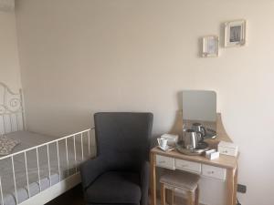 a room with a chair and a table with a mirror at Novara Il Gallo in Lumellogno