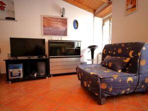 a living room with a chair and a television at Casa Paola 5 Terre in Biassa +7 photos