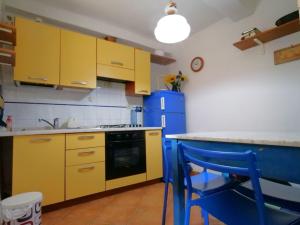 a kitchen with yellow cabinets and a blue refrigerator at Casa Paola 5 Terre in Biassa