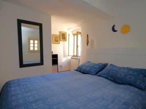 a bedroom with a blue bed and a mirror at Casa Paola 5 Terre in Biassa