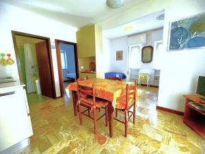 a dining room with a table and chairs in a room at NAONIS - Appartamenti in Bibione