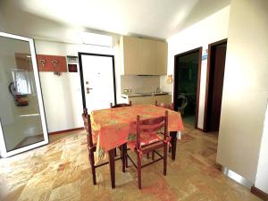 a kitchen with a table with a red table cloth on it at NAONIS - Appartamenti in Bibione
