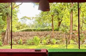 a view of a garden from a window with a table at Karibu Burudika Lodge in Bagamoyo