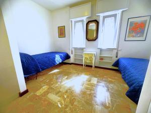 a room with two blue beds and a mirror at NAONIS - Appartamenti in Bibione