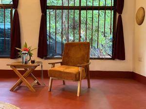 a chair and a table in a room with a window at Karibu Burudika Lodge in Bagamoyo