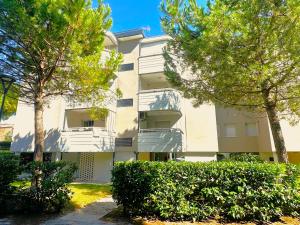 an apartment building with trees in front of it at NAONIS - Appartamenti in Bibione