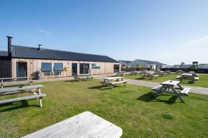 a group of picnic tables in the grass in front of a building at Aurora Beacon View in Lossiemouth