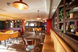 a restaurant with tables and chairs and a bar at Aurora Beacon View in Lossiemouth