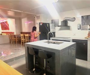 a woman standing in a kitchen with a refrigerator at Nhà trọ Lý Liêm in HÆ°ng YÃªn