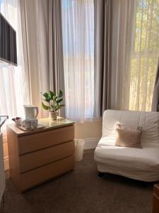 a living room with a white couch and a window at The Avenue GuestHouse in Newcastle upon Tyne