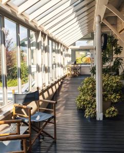 a porch with chairs and tables and windows at Yourte chaleureuse in Bois-le-Roi