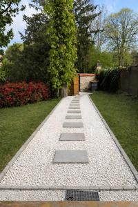 a stone walkway in a garden with flowers at Yourte chaleureuse in Bois-le-Roi +2 photos