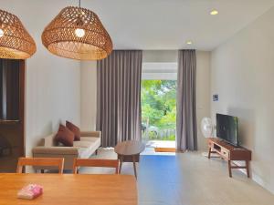 a living room with a couch and a table and a tv at Baan Suan Poolsap - Haad Rin Beach in Haad Rin